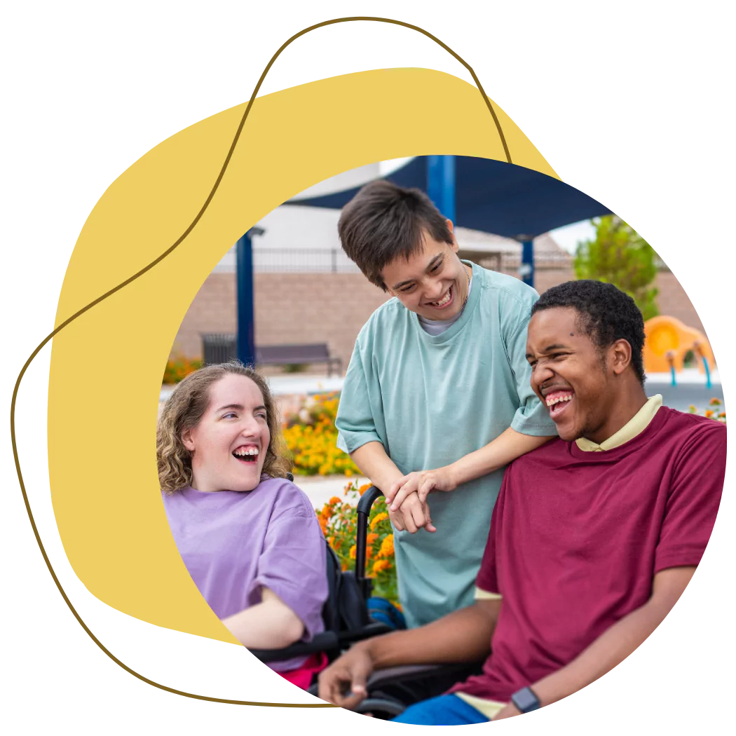 A group of 3 disabled friends are laughing and smiling together while spending time outdoors
