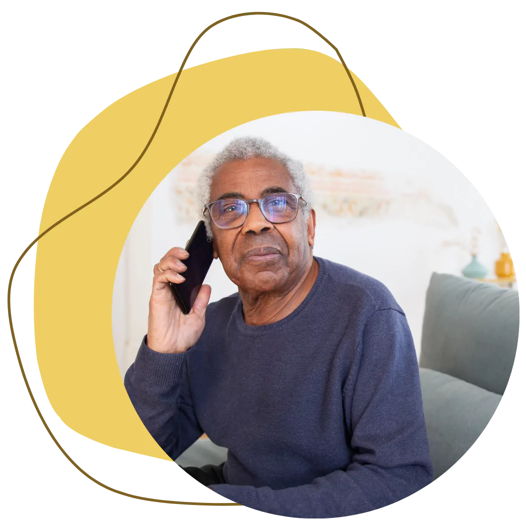 An elderly man is on the phone talking to Adhvi Care & Support and making a referral for a loved one
